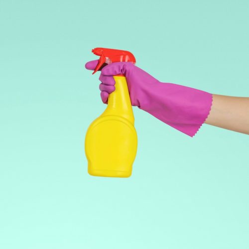 person holding yellow plastic spray bottle